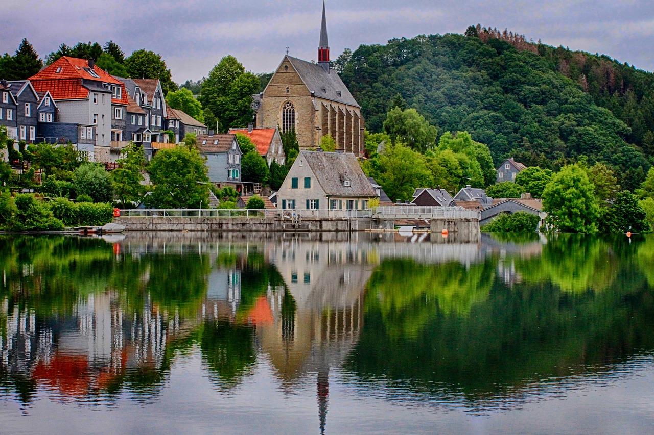 Beyenburger Stausee mit der Klosterkirche und Schieferhäusern, die sich im Wasser spiegeln