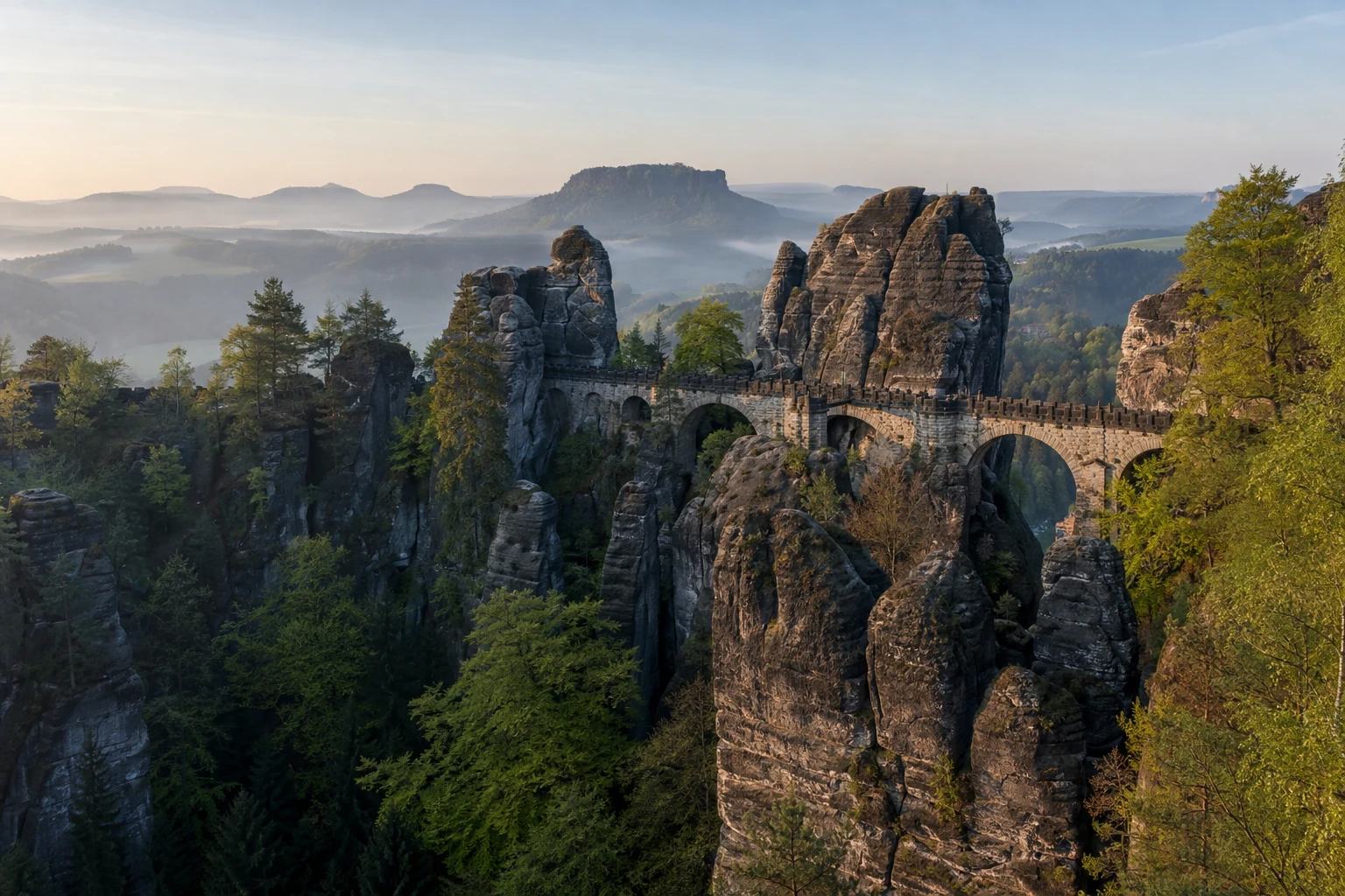 Basteigebiet: Felsbrücke und bewaldete Türme über dem Elbtal