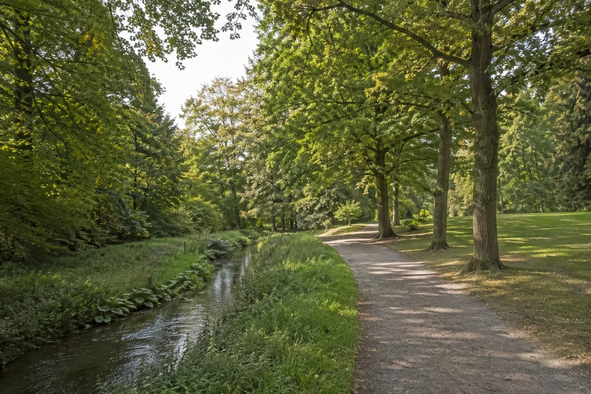 Baunatal: Baunatal Altenbauna: Altenbauna: kleiner Baunabach im grünen Stadtpark mit Weg und Laubbäumen