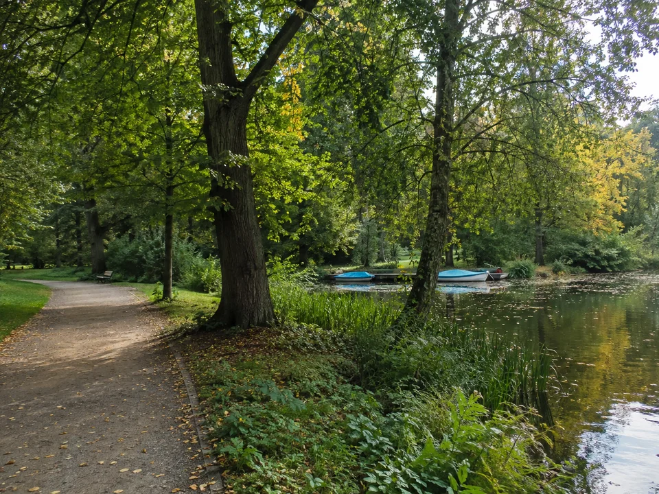 Bremerhavener Parklandschaft: Alter Laubbaumbestand und stiller Bootsteich im Speckenbütteler Park, geschwungener öffentlicher Spazierweg