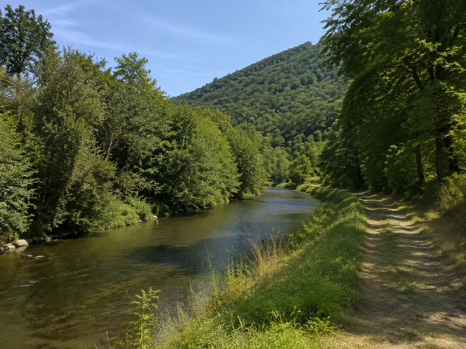 Filstal bei Faurndau: Schmaler Fluss mit grünen Uferbäumen und Fußweg unter niedrigen bewaldeten Talhängen ohne Stadtgebäude