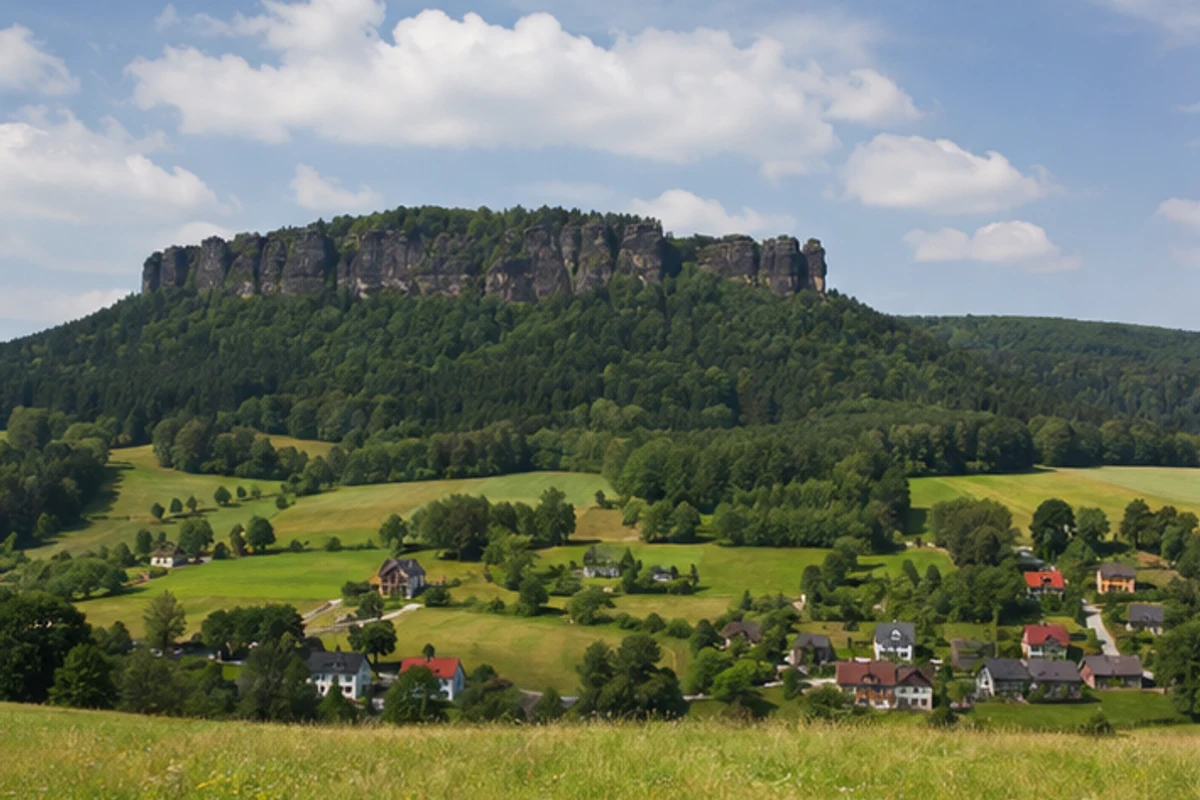 Gohrisch: Kurort Gohrisch: Gohrisch: bewaldeter Tafelberg über Wiesen und Dörfern