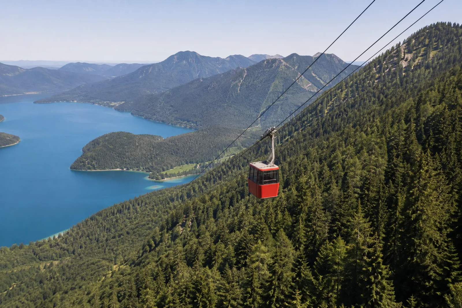 Herzogstandbahn: rote Kabine über bewaldetem Steilhang am Walchensee