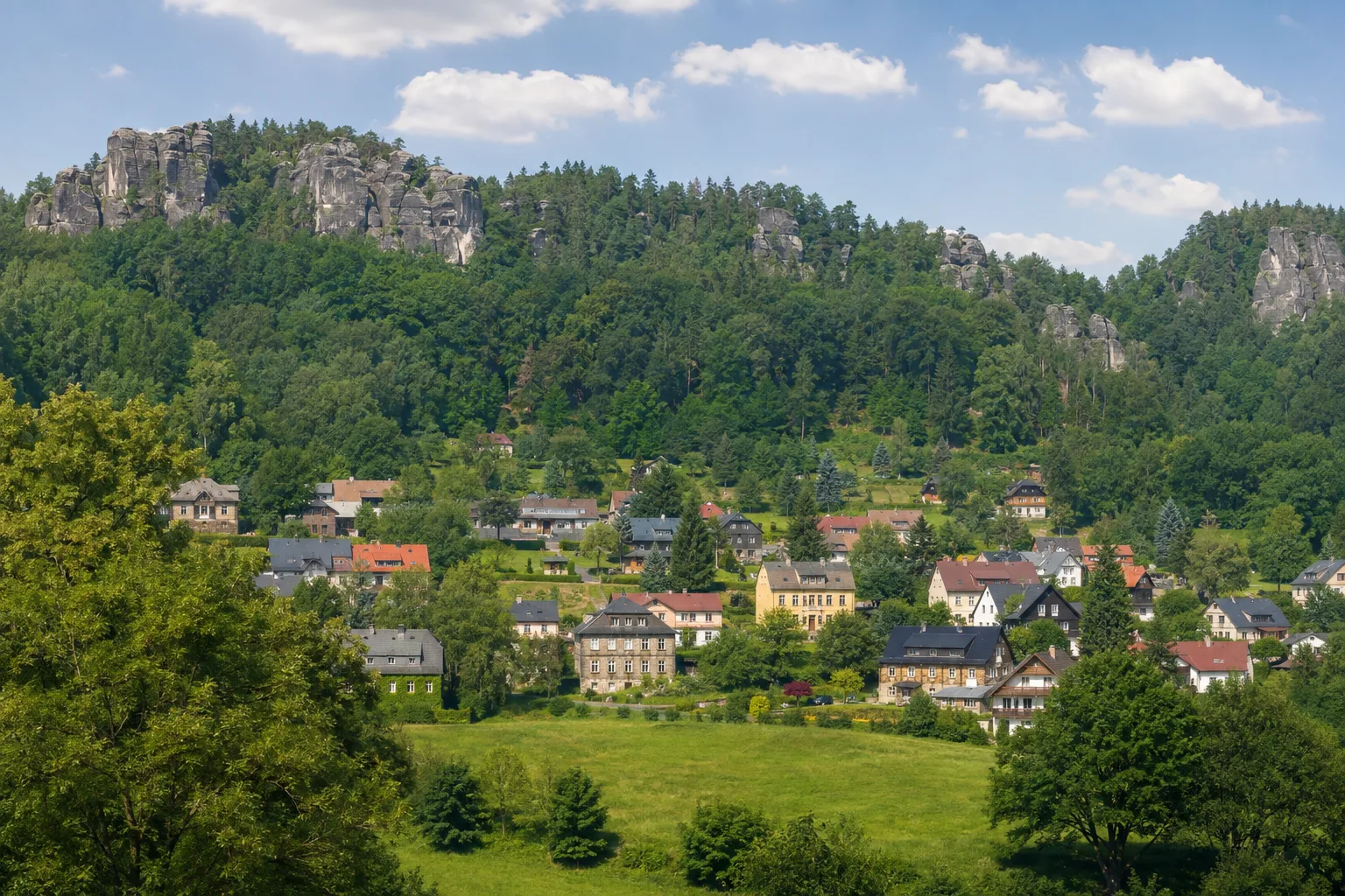 Jonsdorf: Jonsdorfer Felsenstadt: zerklüftete Sandsteinfelsen über dem grünen Kurort