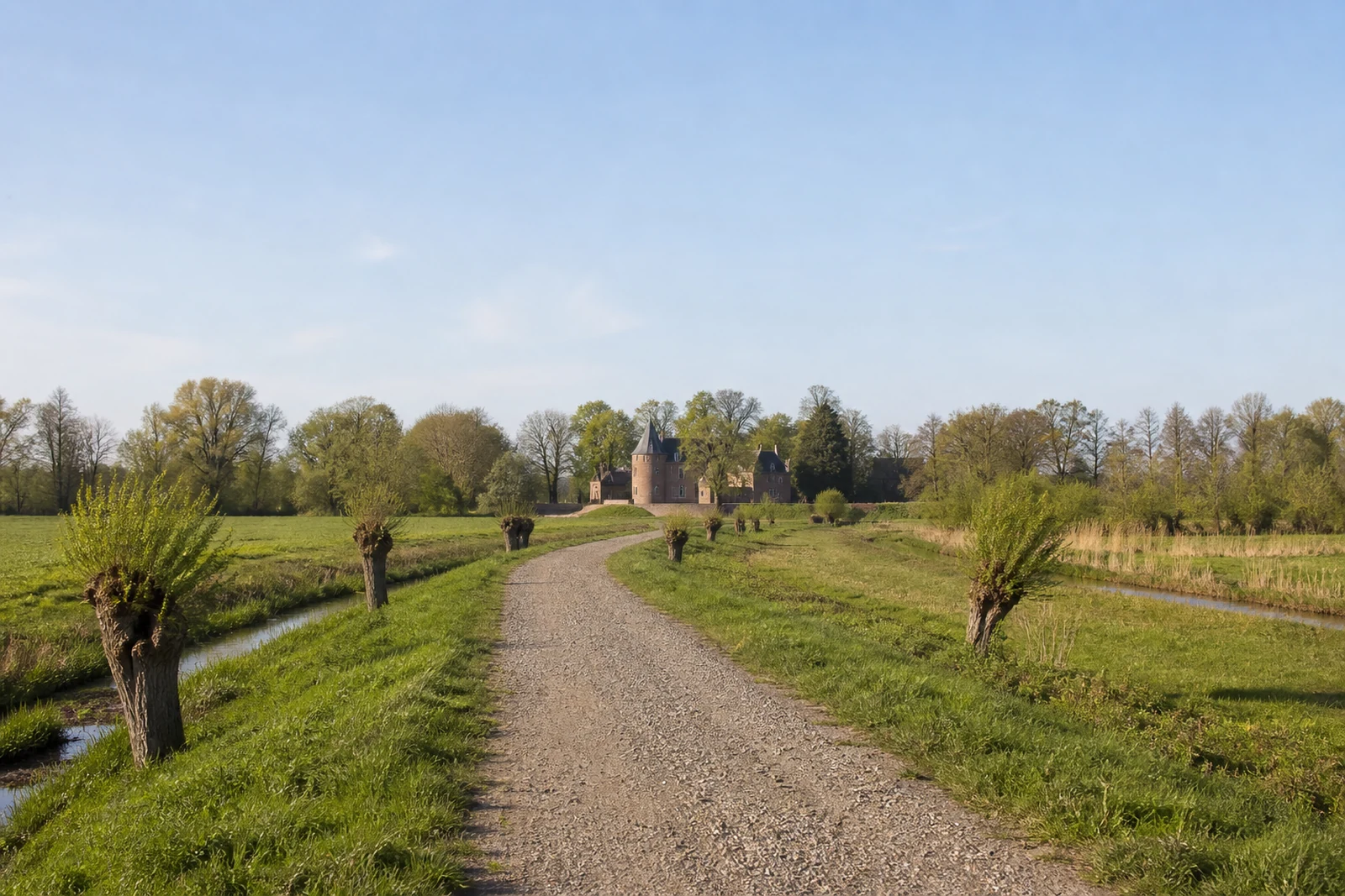 Wanderweg durch flache Wiesen und Kopfweiden bei Burg Linn in Krefeld