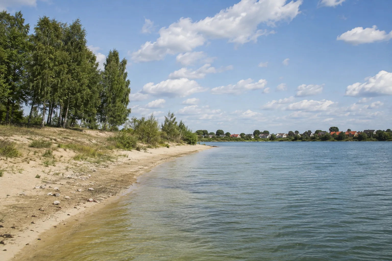 Geierswalder Ortsufer: Offene Wasserfläche und niedrige sandige Ufer am sächsischen Dorf
