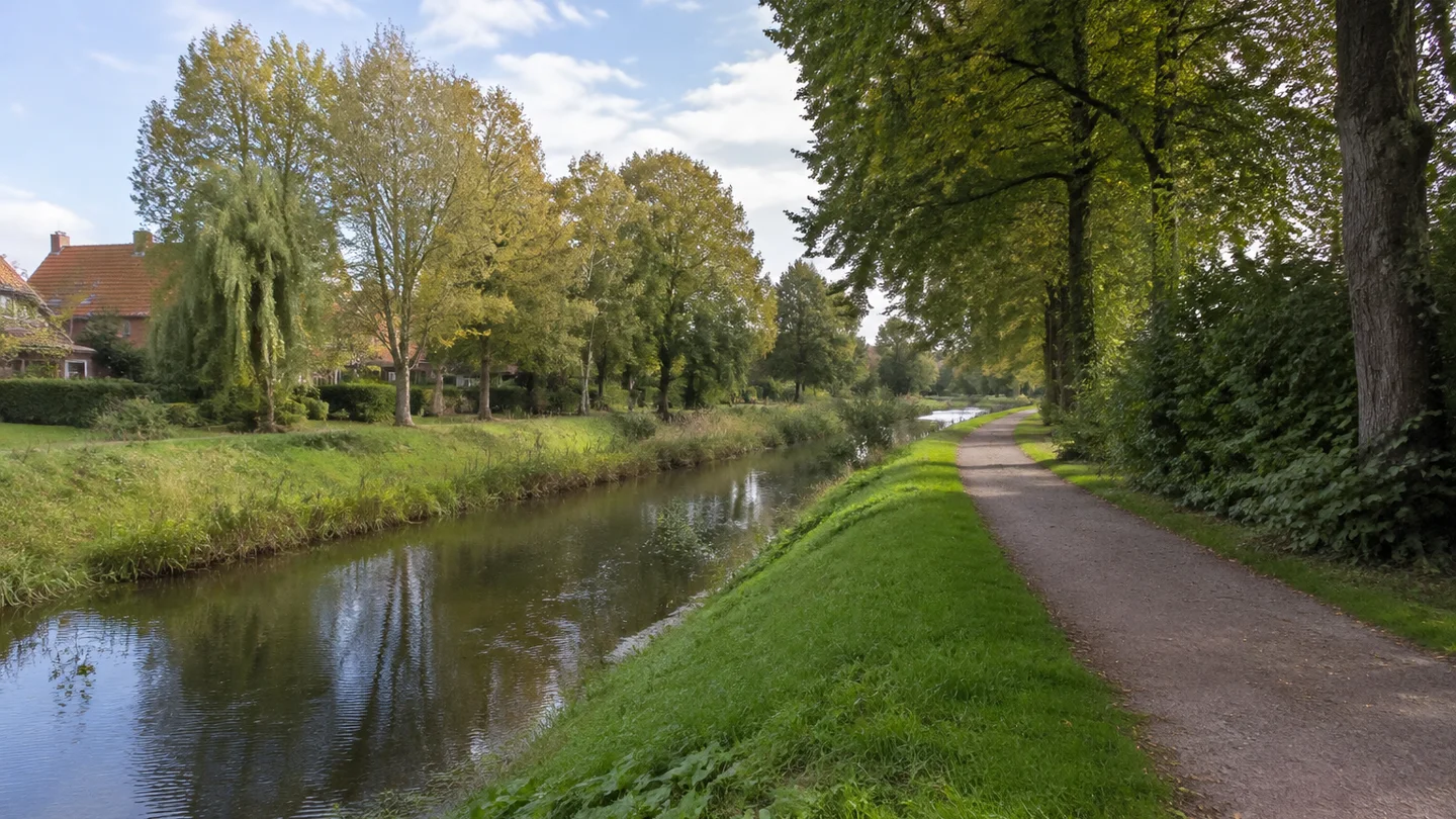 Lilienthal: Amtsgarten und Wörpe: Kleiner langsam fließender Fluss mit Grasböschungen, Laubbäumen und öffentlichem Uferweg am grünen Siedlungsrand