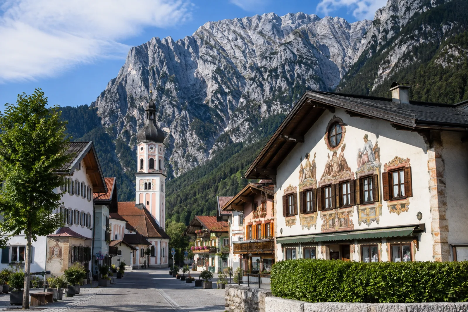 Mittenwald: Mittenwald: bemalte Häuser und Kirchturm vor den steilen Karwendelwänden