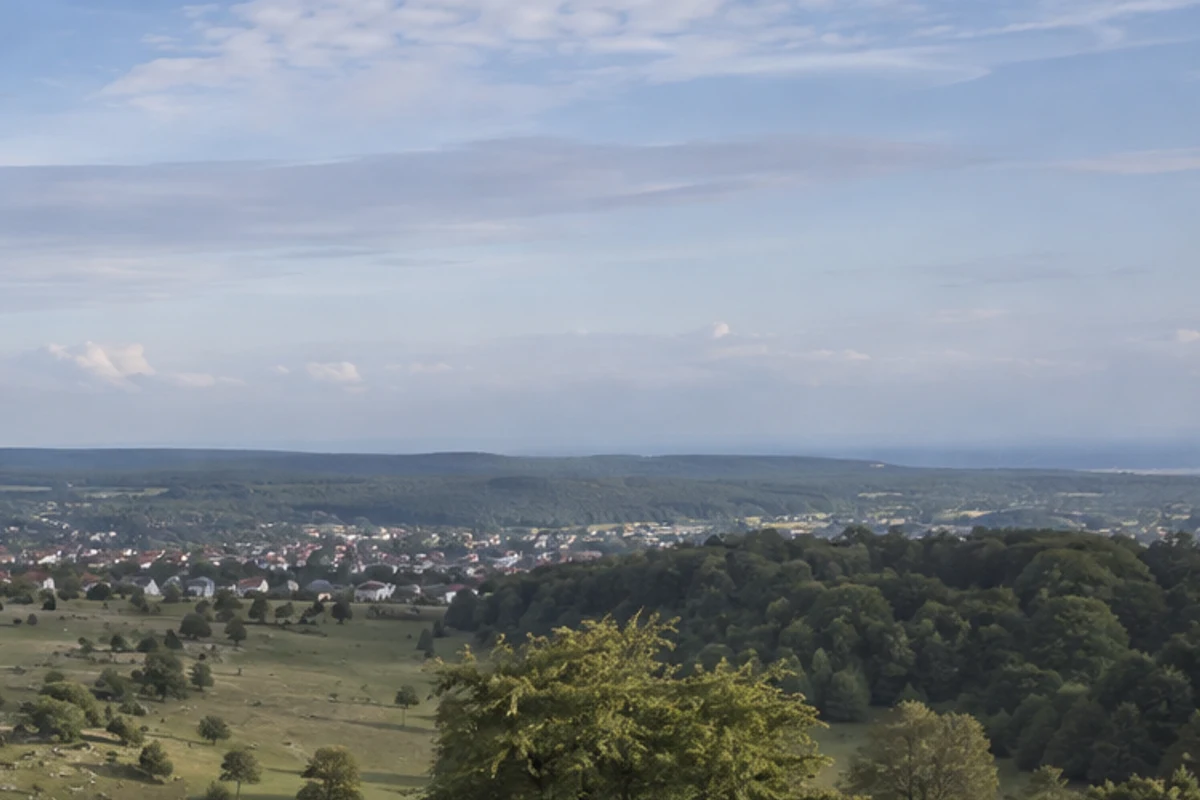 Großes Lautertal: klarer Bach zwischen Wiesenhängen und Buchenwald