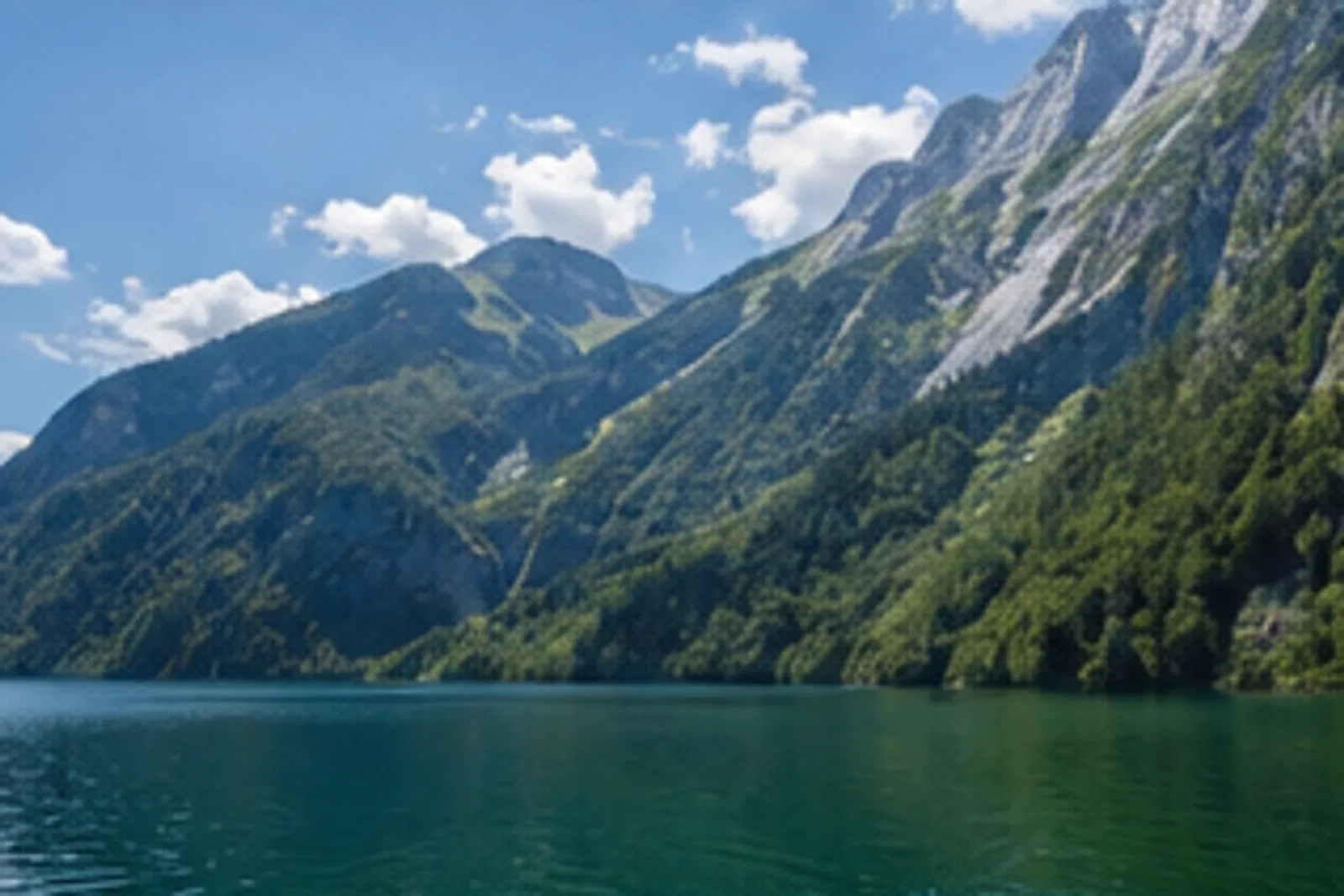 Königsseeufer: dunkelgrüner Alpensee unter steilen Waldflanken