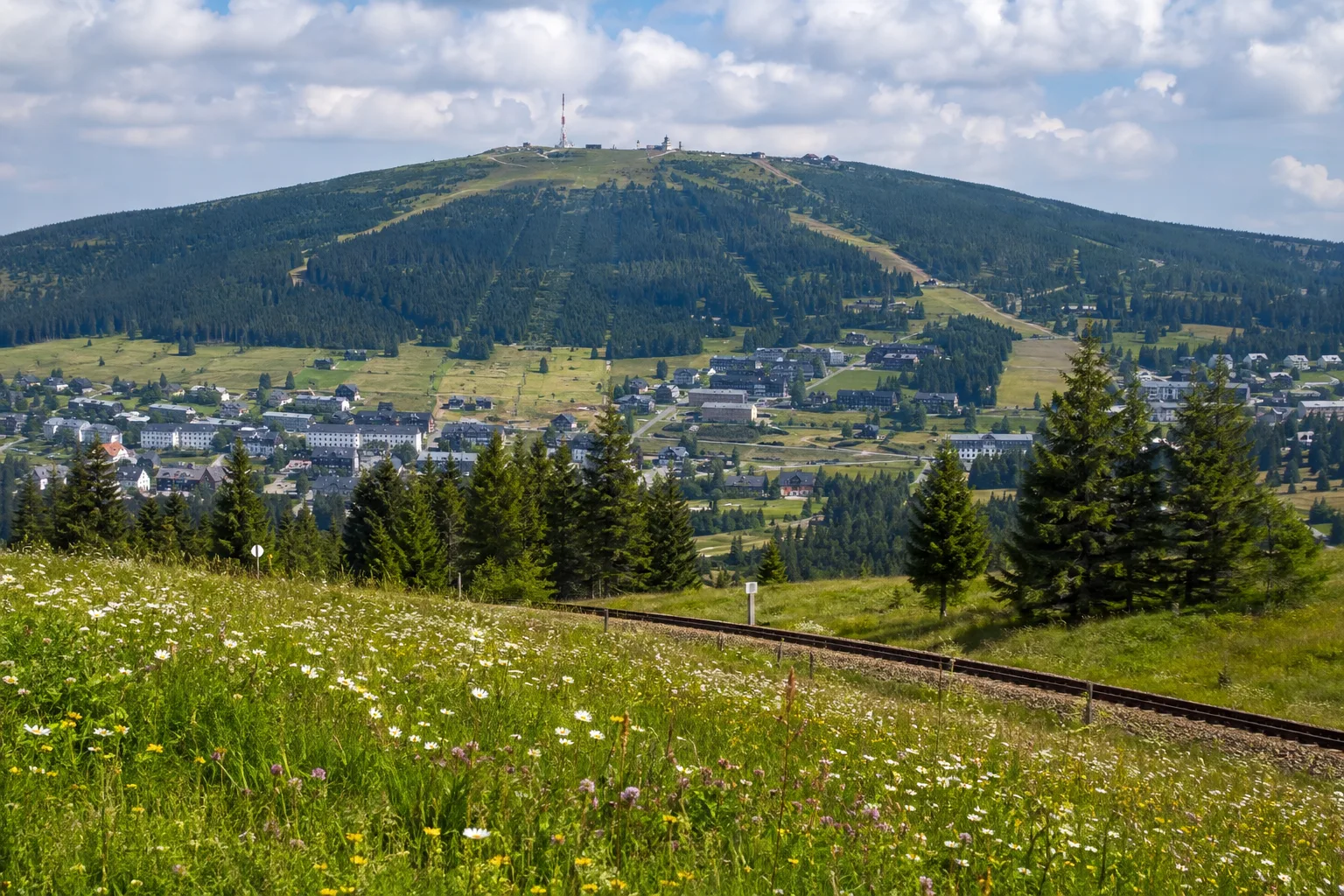Oberwiesenthal: Oberwiesenthal am Fichtelberg: Bergstadt unter breitem bewaldetem Gipfel mit Bergwiesen