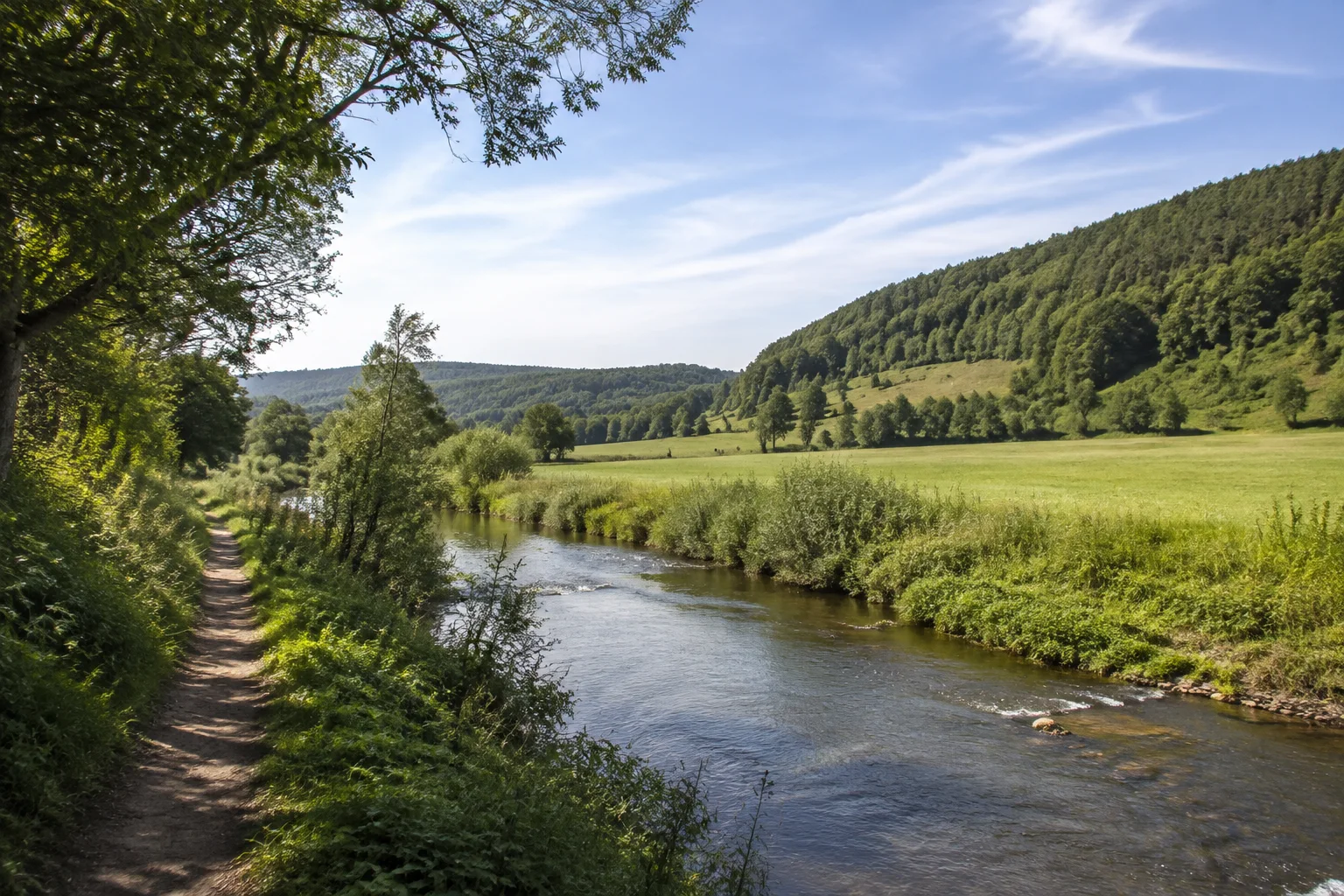 Ostheim vor der Rhön: Ostheim vor der Rhön: Streutal bei Ostheim: kleiner Fluss in grünem Tal mit Wiesen und niedrigen Waldhängen, Weg zwischen Ufergehölzen.