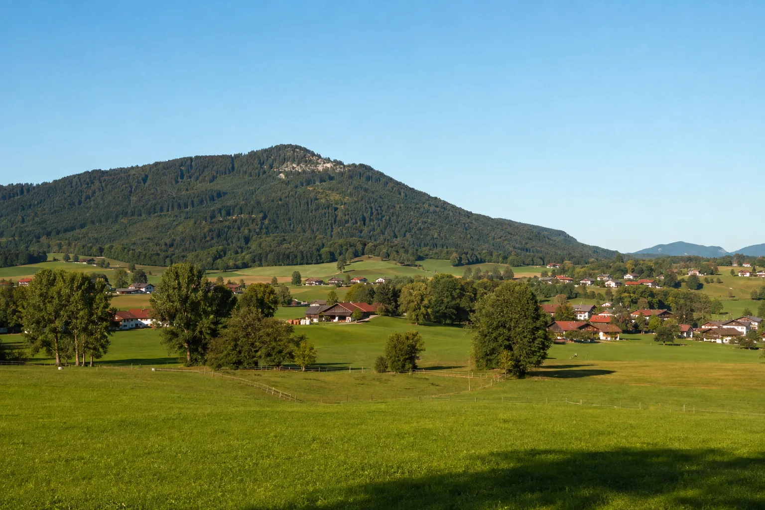 Samerberg: Grainbach: Samerberg: weite grüne Hochmulde mit Wiesen und Höfen unter bewaldetem Hochriesrücken