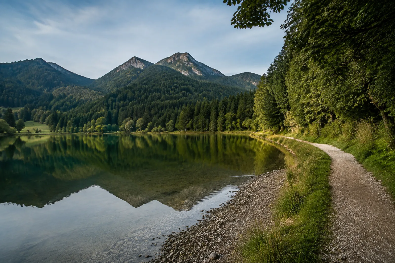 Spitzingsee: kleiner hochgelegener Bergsee zwischen dunklen Bergwäldern