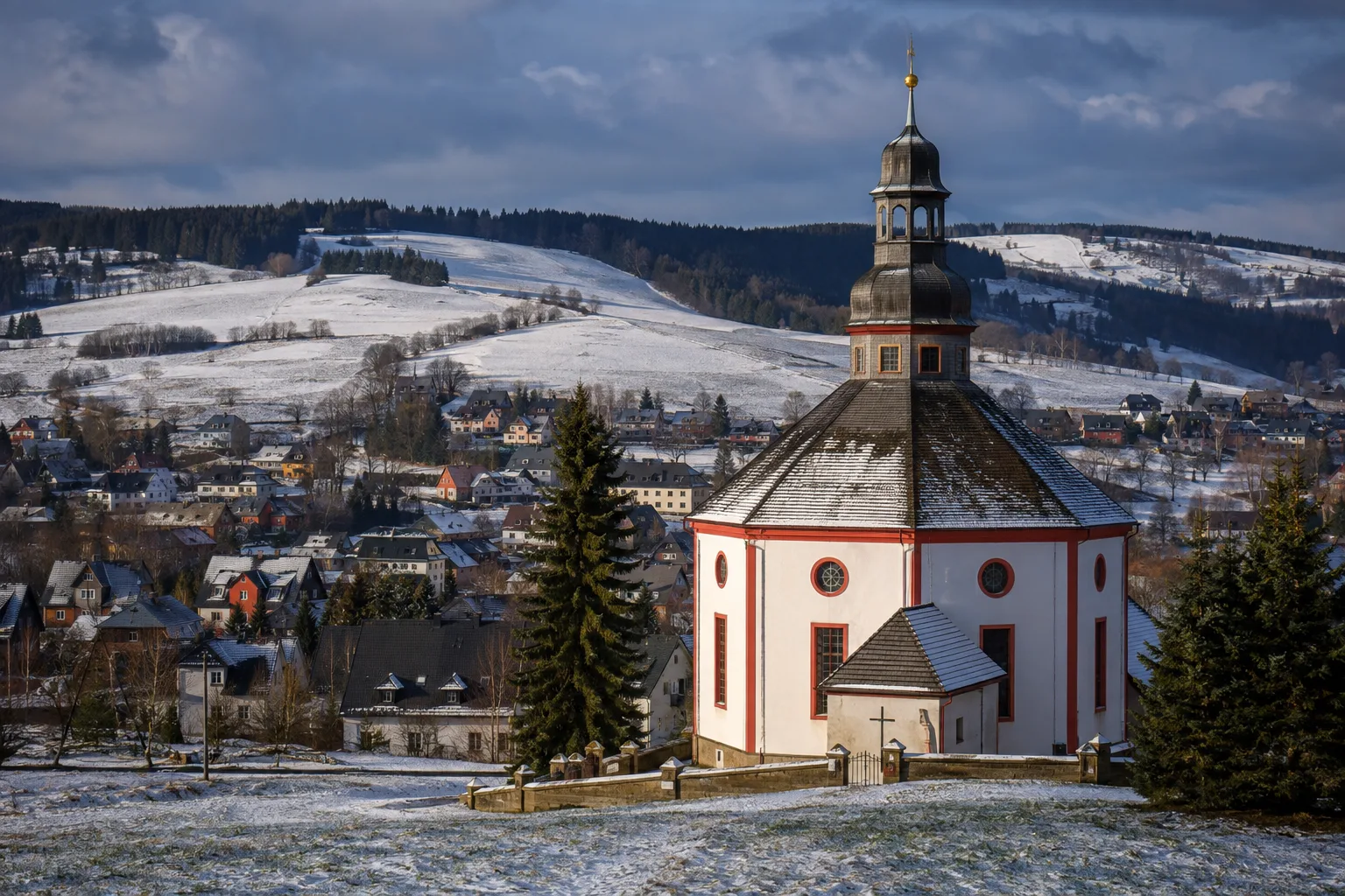Seiffen: Seiffener Bergkirche: kleine achteckige Bergkirche zwischen verschneiten Erzgebirgshängen
