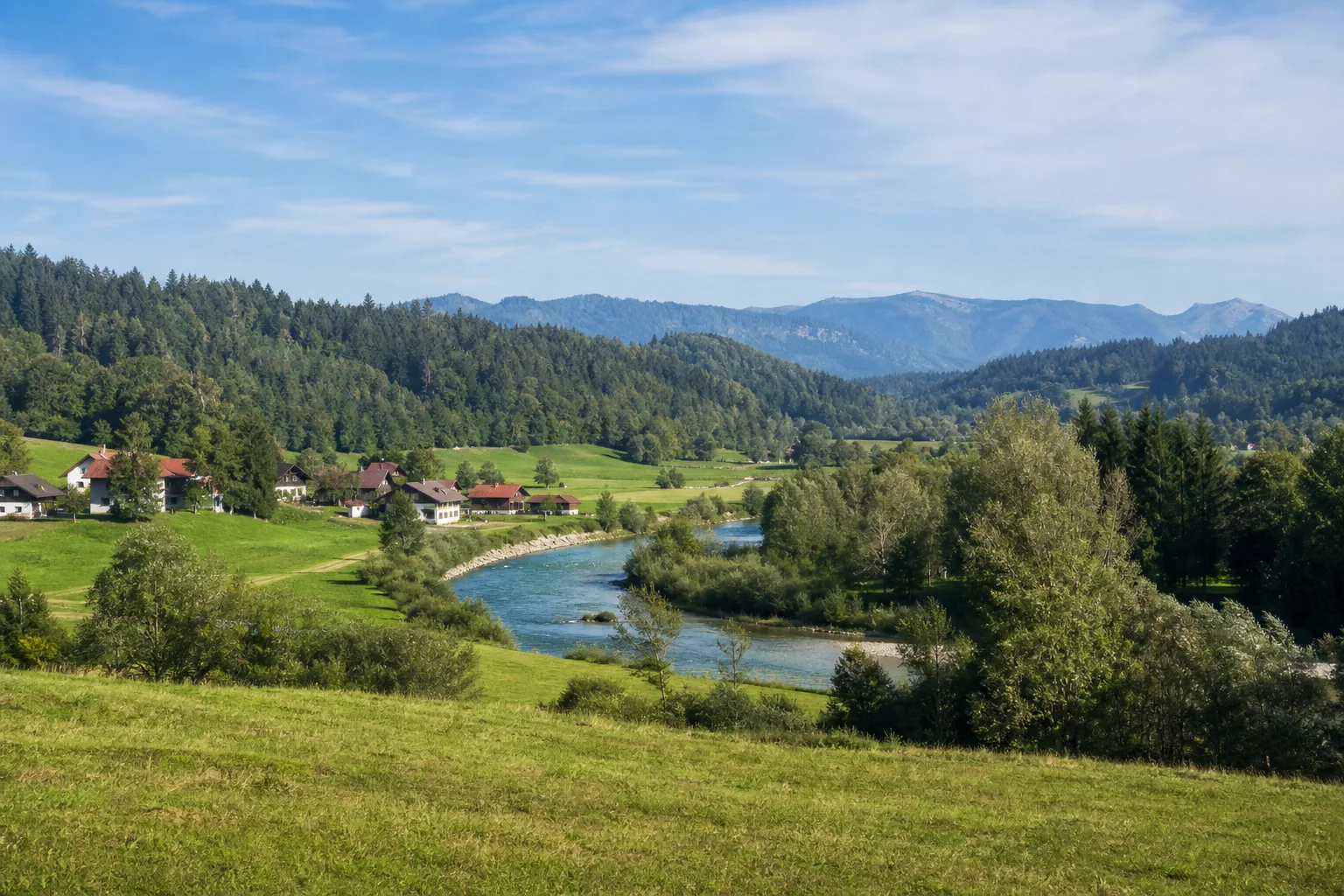 Hammer bei Siegsdorf: grünes Tal der Roten Traun mit kleinem Dorf und bewaldeten Rücken