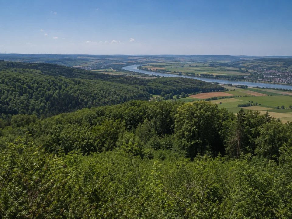 Nördlicher Steigerwald bei Eltmann: Bewaldete niedrige Hügel oberhalb Eltmanns mit Blick auf einen Teil des breiten Maintals, keine erfundene Burgruine