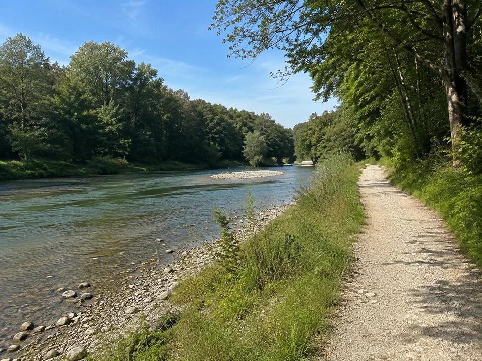 Loisach bei Wolfratshausen: ruhiger mittelbreiter Fluss mit grünen Uferbäumen und flachem Kiesweg